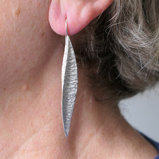 Long silver textured pod earrings