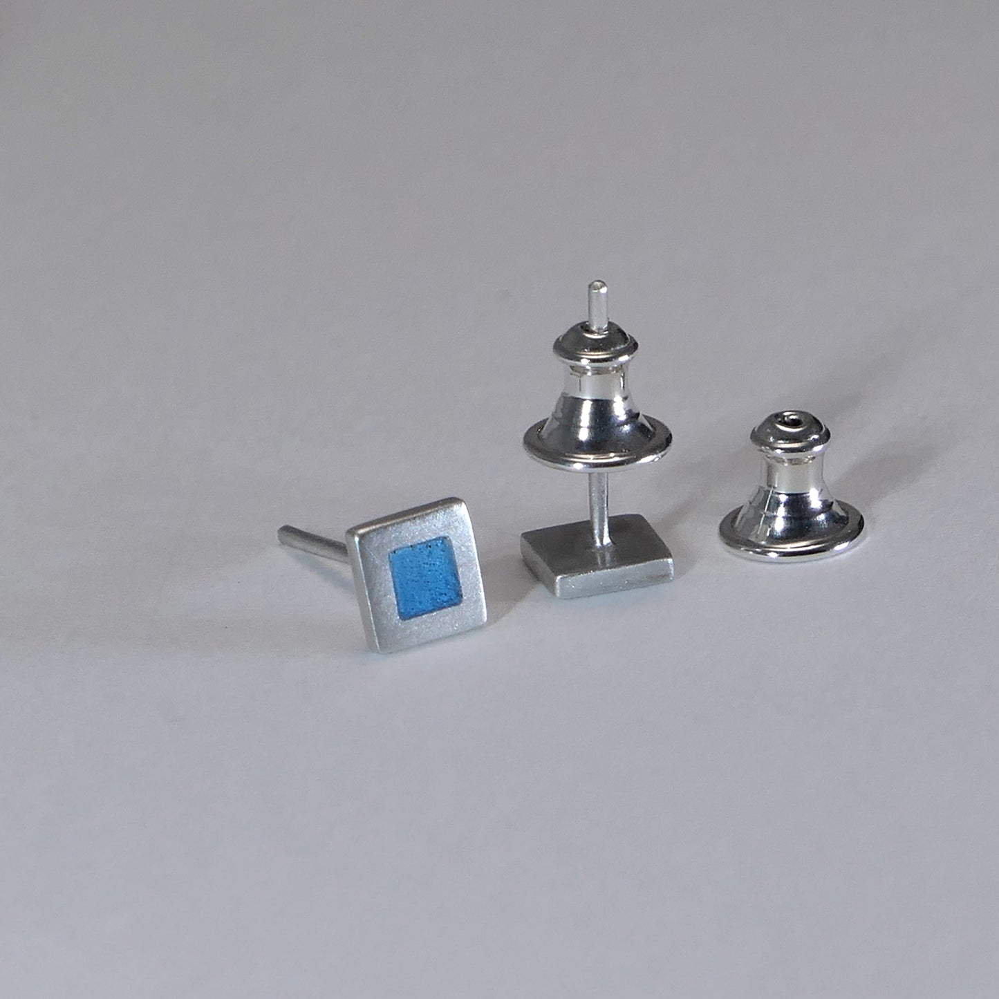 Tiny sterling silver square stud earrings with blue turquoise enamel
