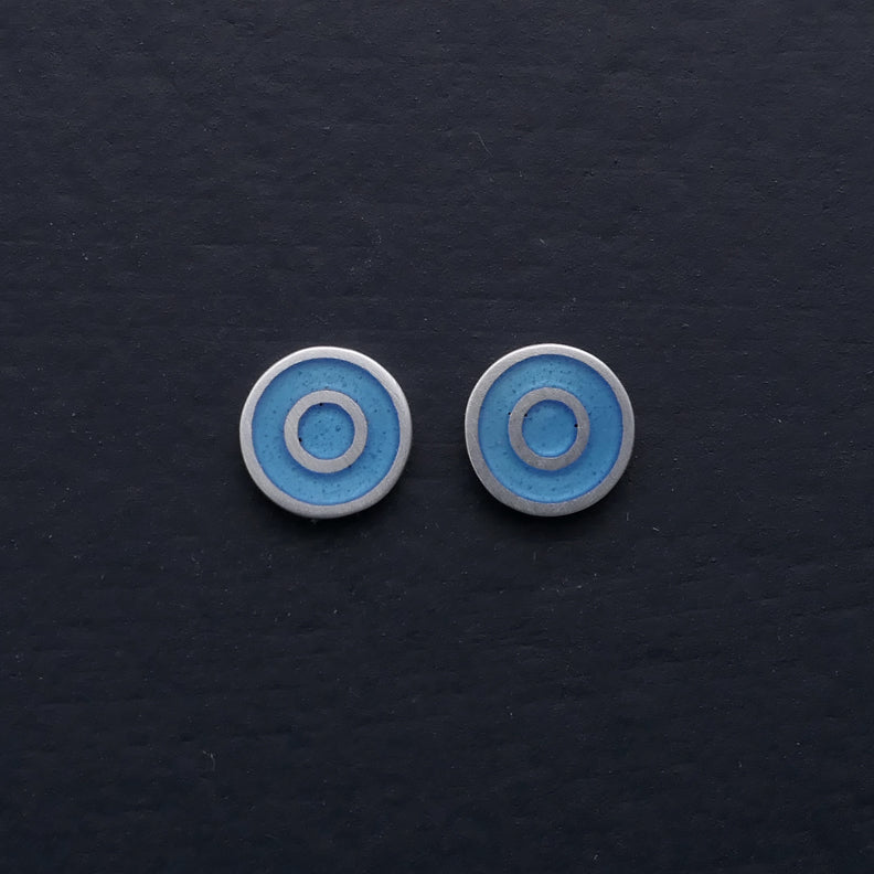 Small round silver ear-stud, concentric. Light blue