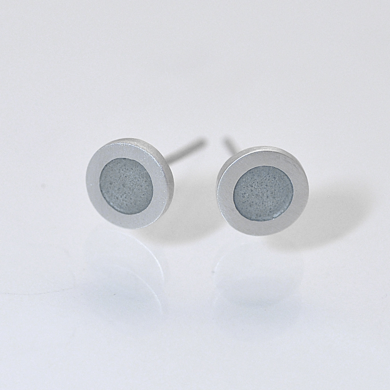 Small flat round ear studs with Mouse grey coloured enamel in the centre
