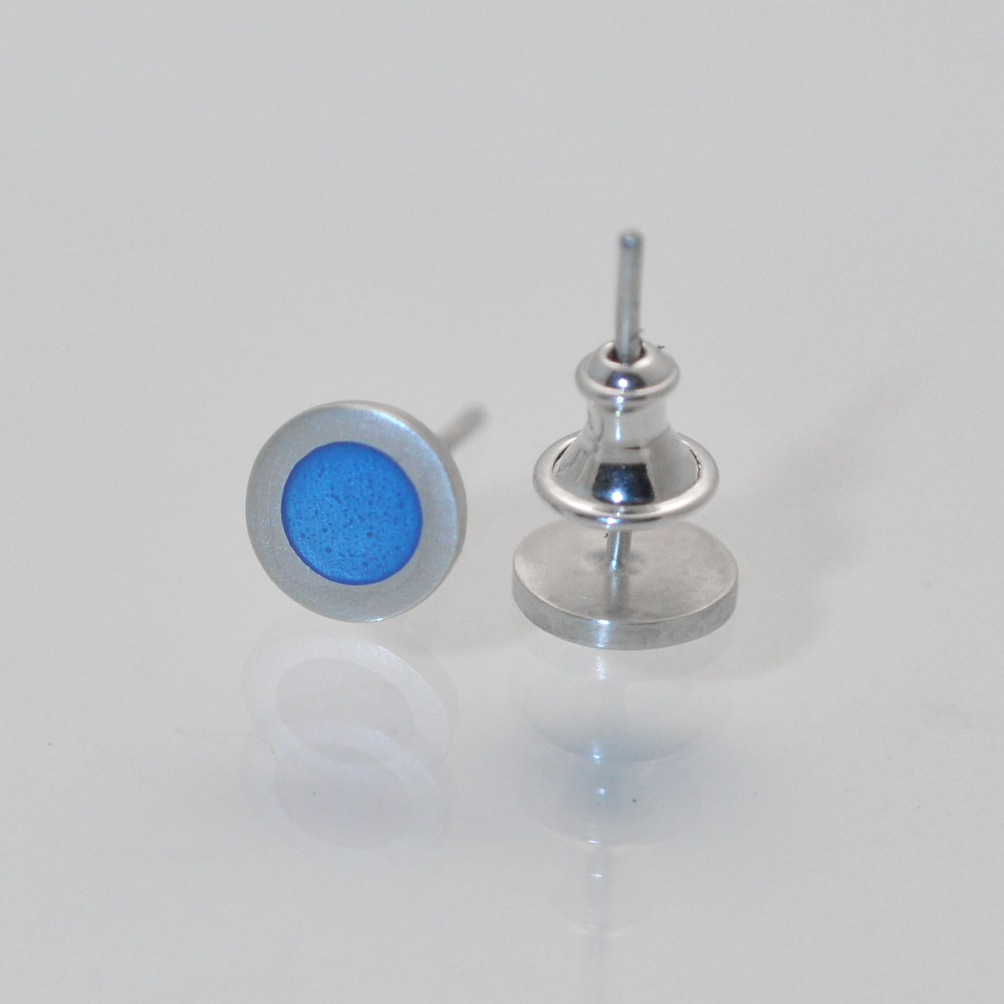 Small round silver flat earstuds, light blue