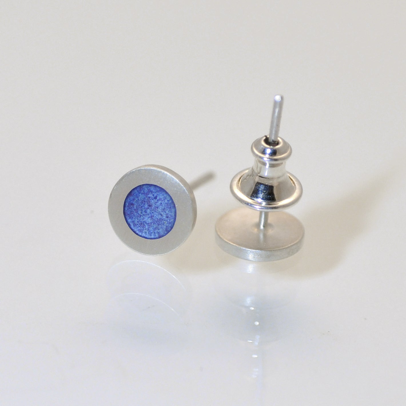 Small flat round ear studs with coloured enamel in the centre