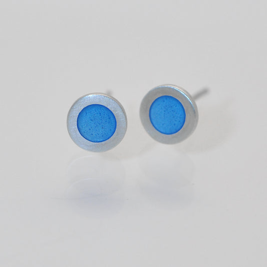 Small flat round ear studs with Light blue coloured enamel in the centre